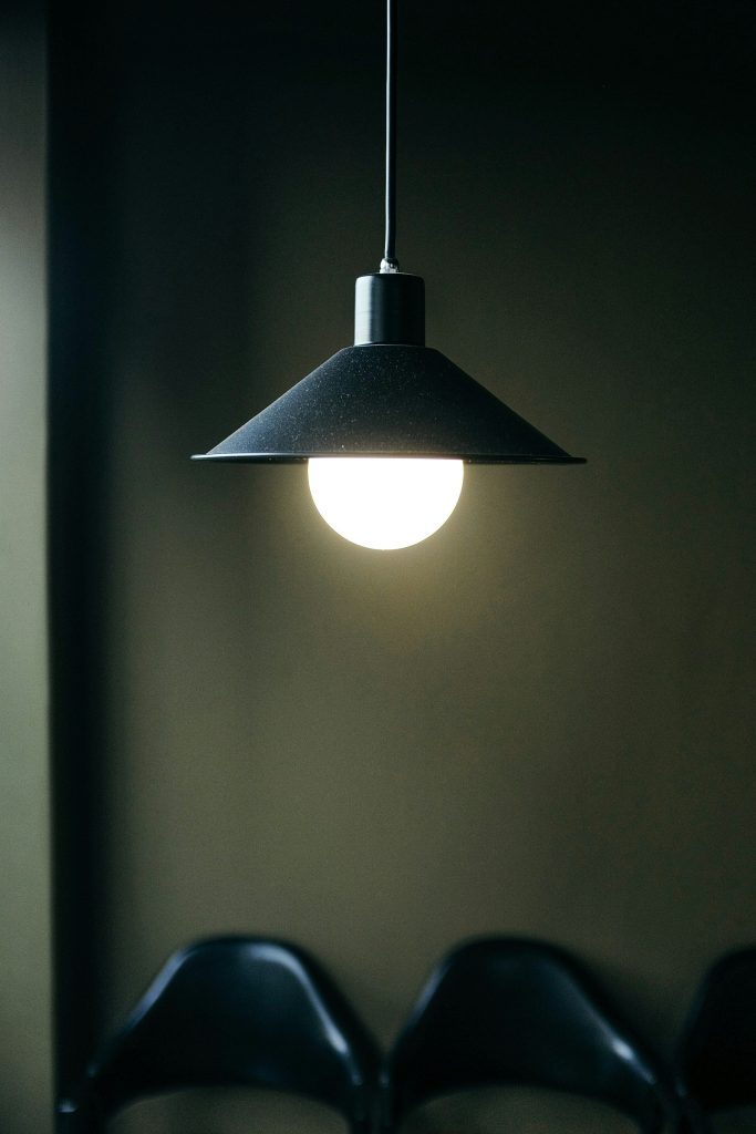 Black pendant lamp glowing in a dark interior