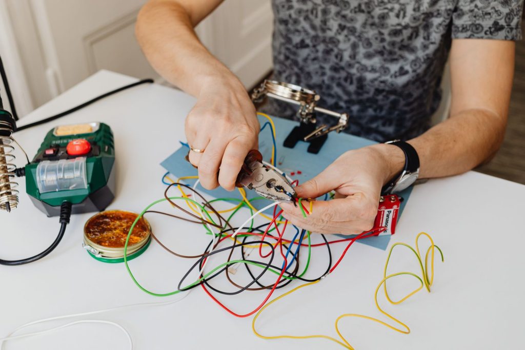 Electrician cutting and preparing coloured wires with pliers