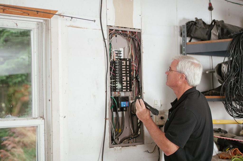 Electrician examining a residential fuse box before an upgrade