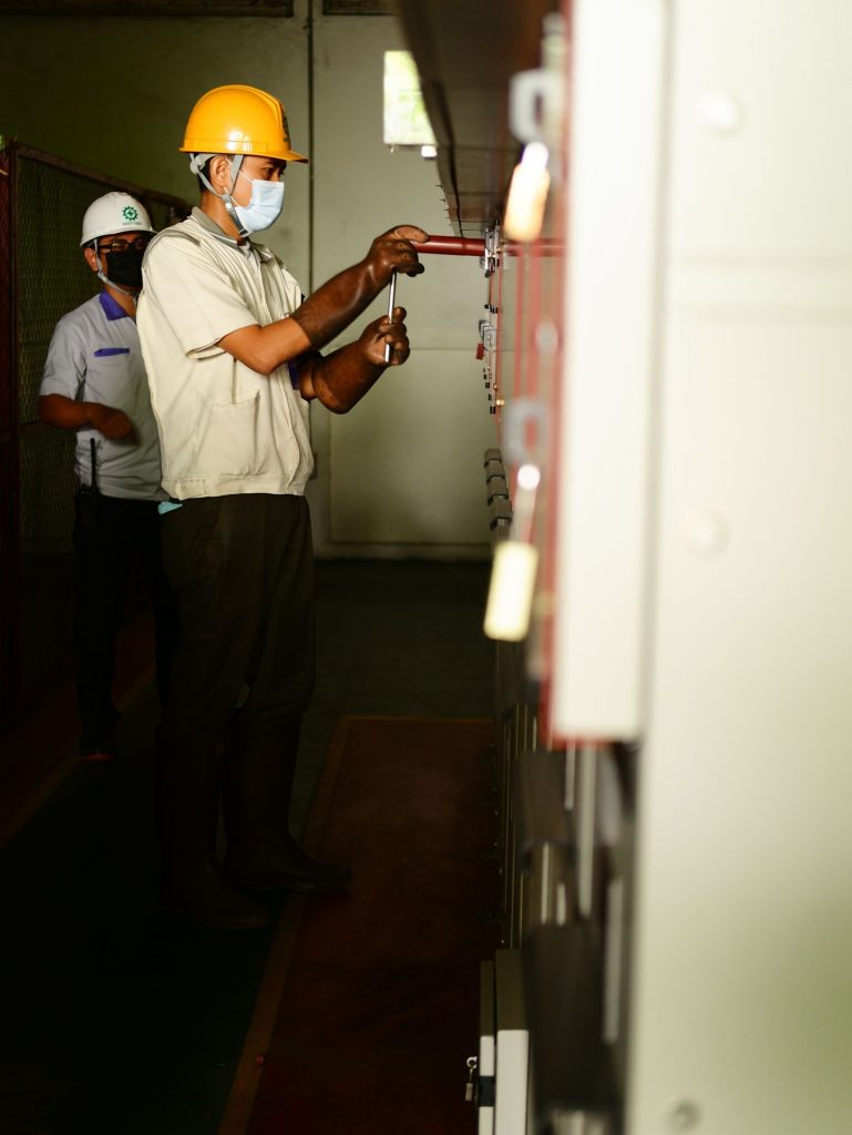 Two electricians working together on electrical control panels