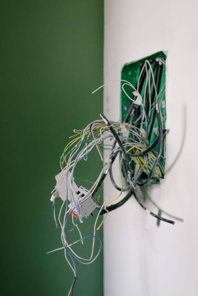 Exposed wires behind a wall socket awaiting repair