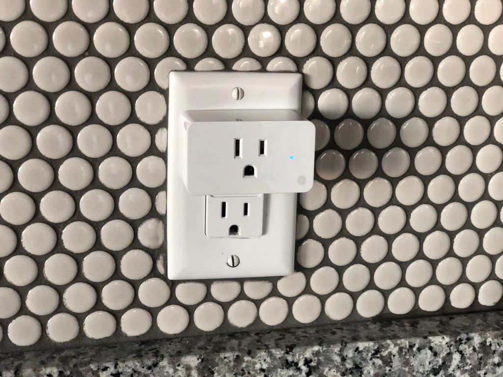 Modern wall outlet installed on a tiled wall