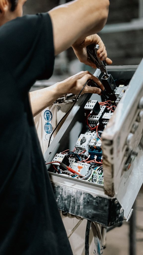 Technician adjusting wires in an electrical control panel