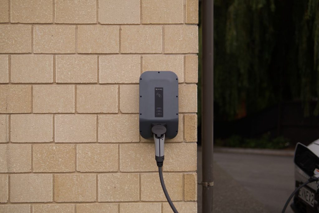 Wall-mounted home EV charger installed on a brick wall